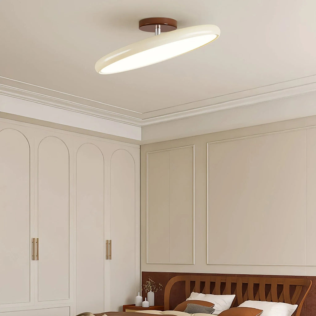 Tilting disc ceiling light, in beige in a bedroom