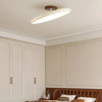 Tilting disc ceiling light, in beige in a bedroom