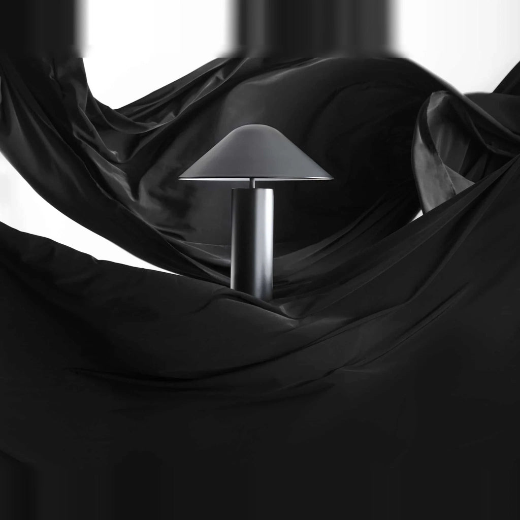 Adjustable cone shade steel table lamp, on a dark drape