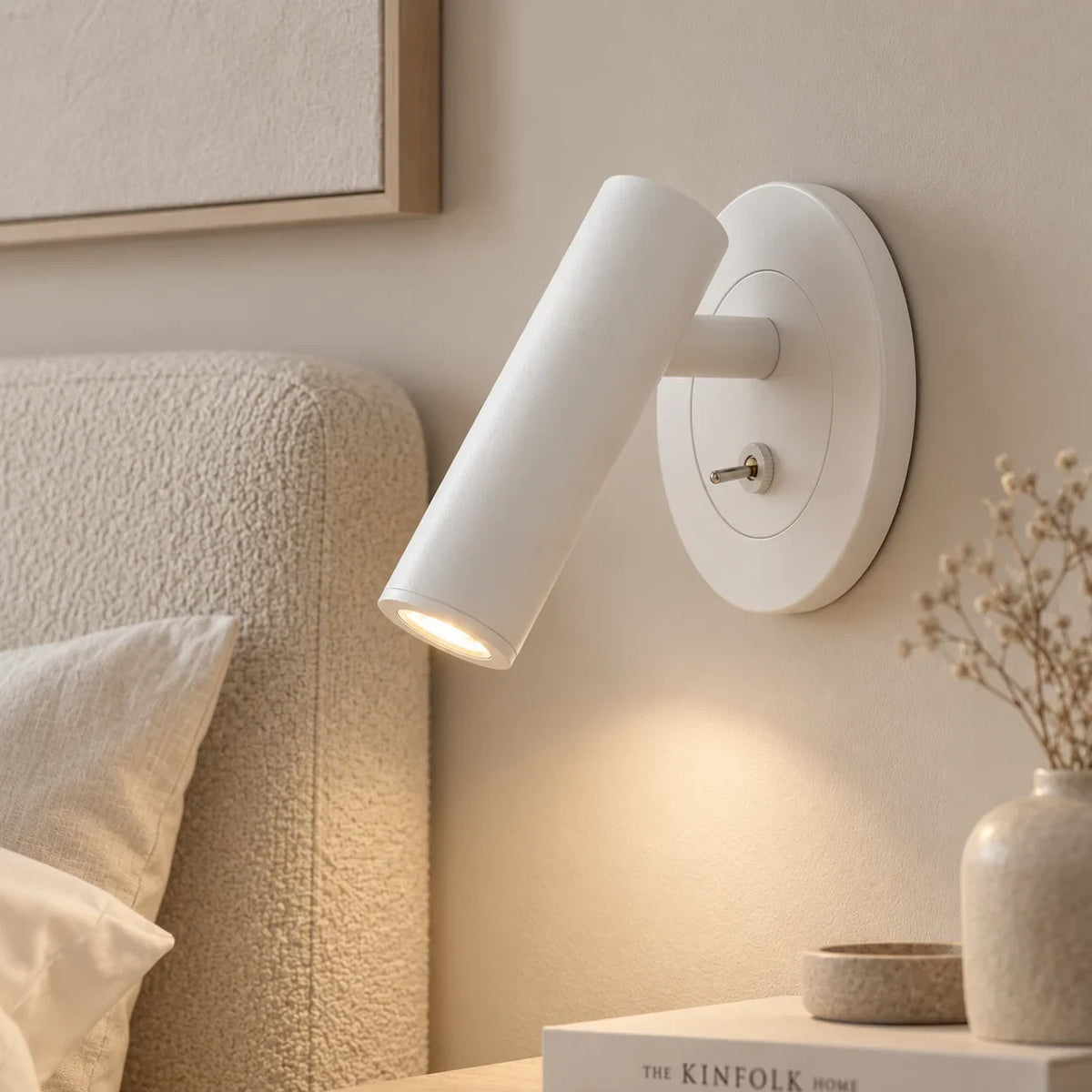 Adjustable reading wall light, in white beside a bed