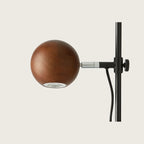 Adjustable round-head reading table lamp, close-up of the walnut head and height clamp