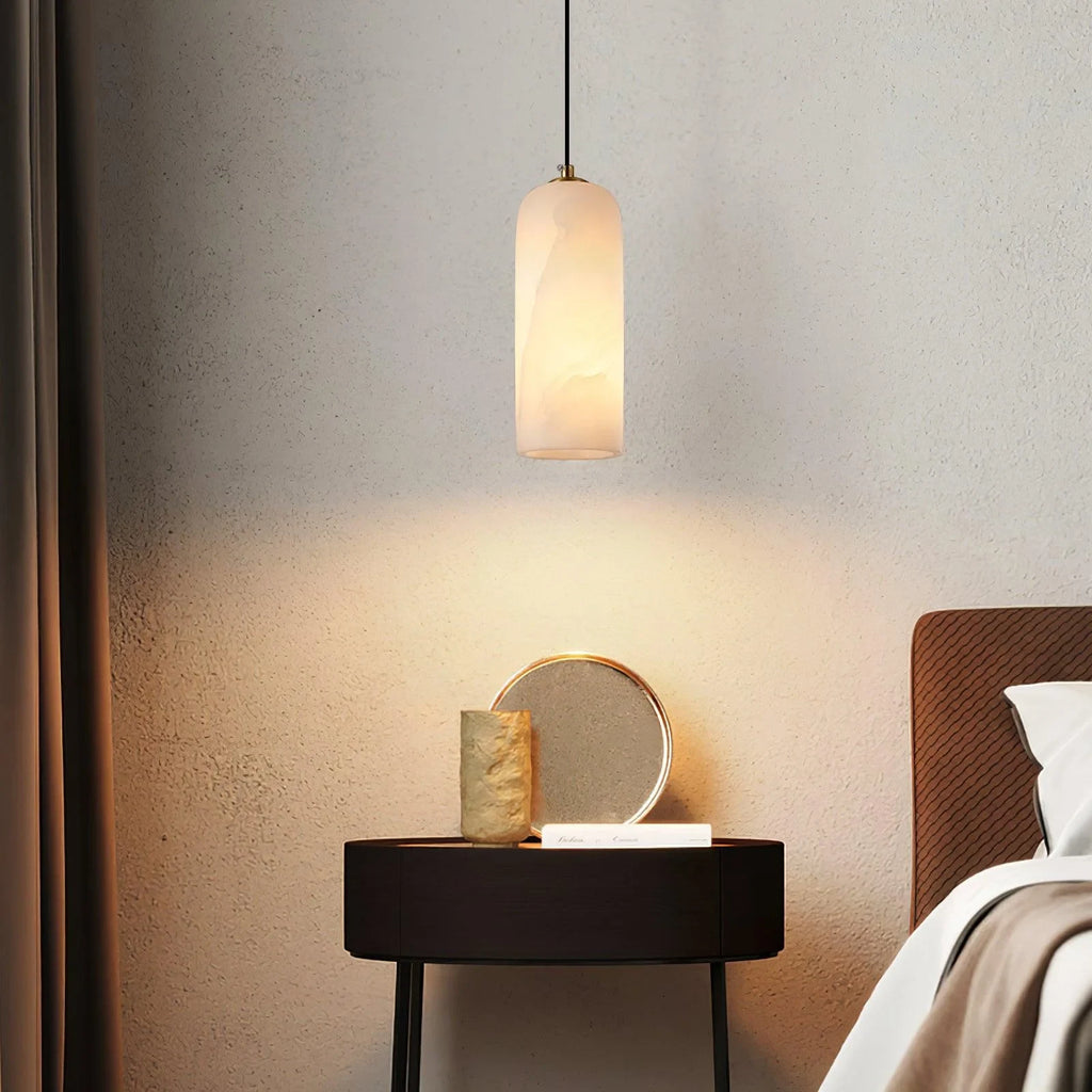 Alabaster cylinder pendant light, beside a bed