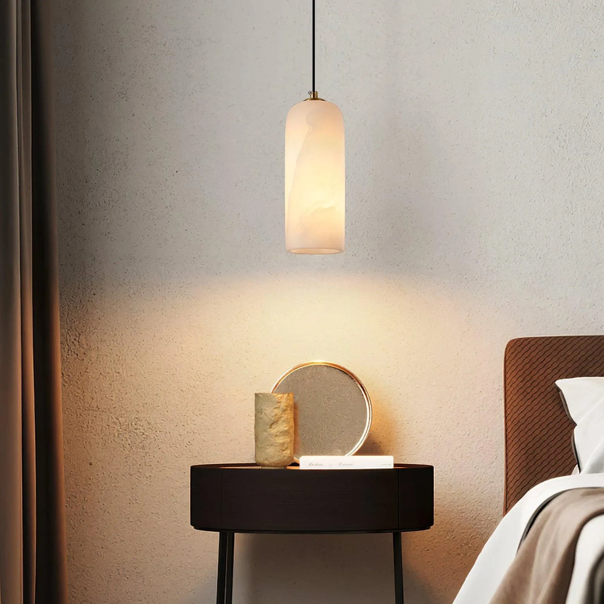 Alabaster cylinder pendant light, beside a bed