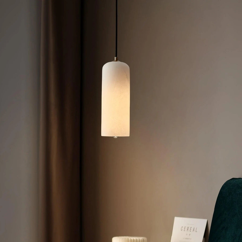 Alabaster cylinder pendant light, lit in a bedroom