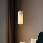 Alabaster cylinder pendant light, lit in a bedroom