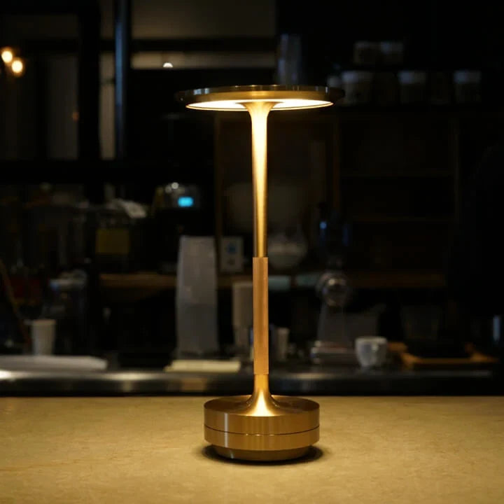 Aluminium cordless table lamp, lit in a room setting