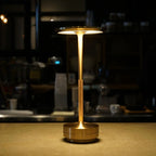 Aluminium cordless table lamp, lit in a room setting