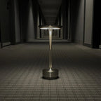 Aluminium cordless table lamp, lit in a room setting
