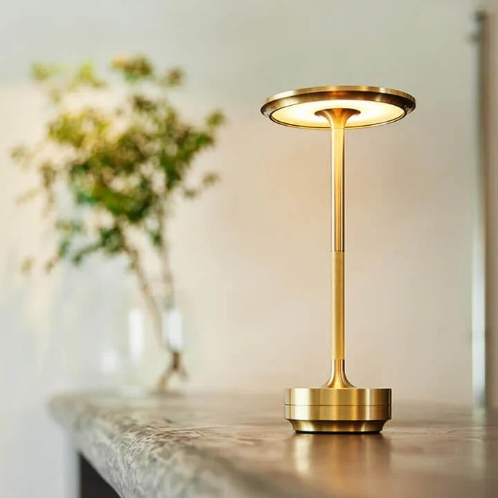 Aluminium cordless table lamp, lit in a room setting
