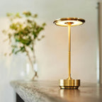 Aluminium cordless table lamp, lit in a room setting