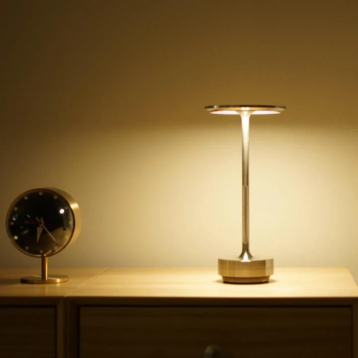 Aluminium cordless table lamp, lit in a room setting