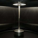 Aluminium cordless table lamp, lit in a room setting