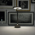 Aluminium cordless table lamp, lit in a room setting