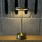 Aluminium cordless table lamp, lit in a room setting