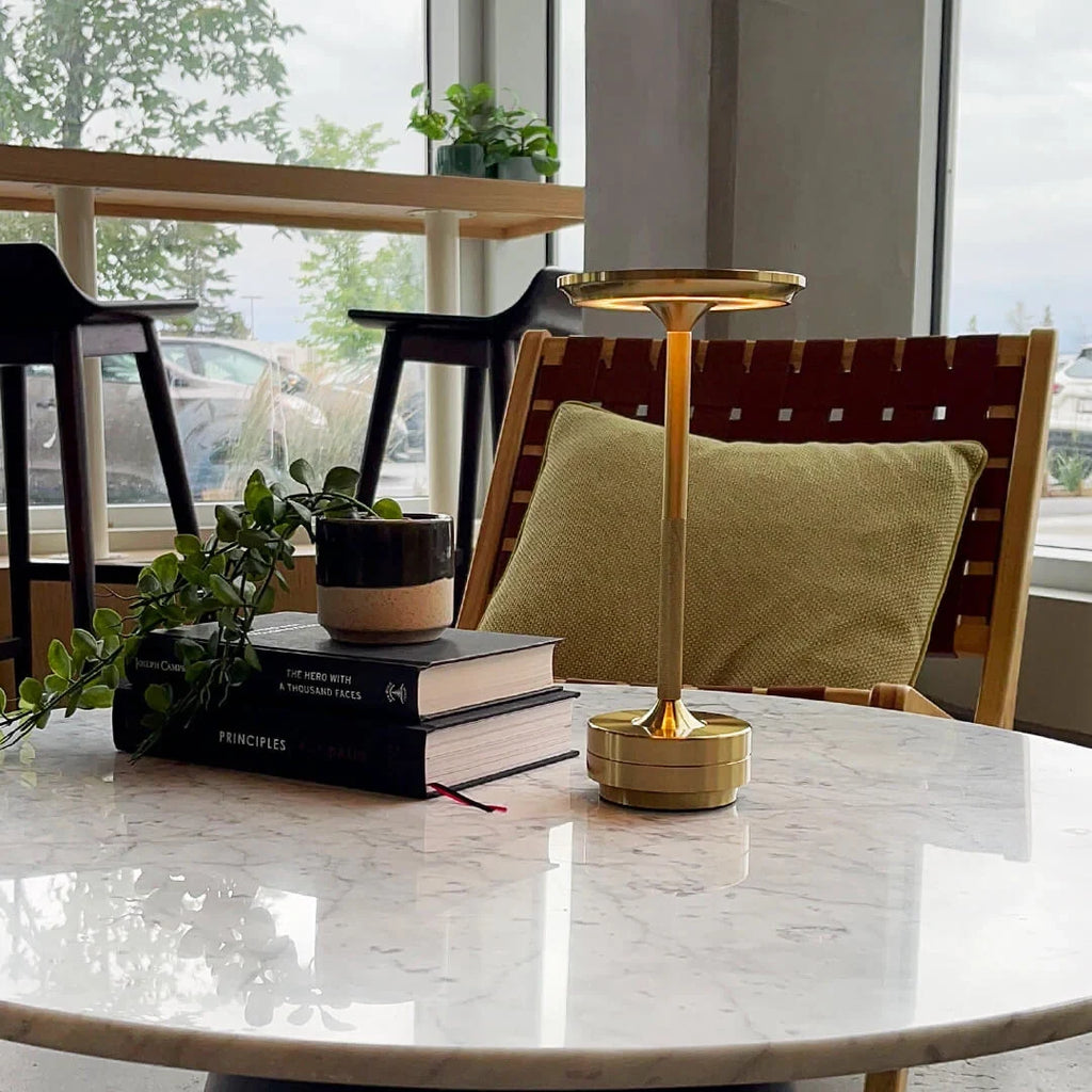 Aluminium cordless table lamp, lit in a room setting