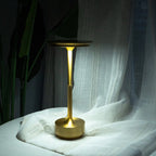 Aluminium cordless table lamp, lit in a room setting