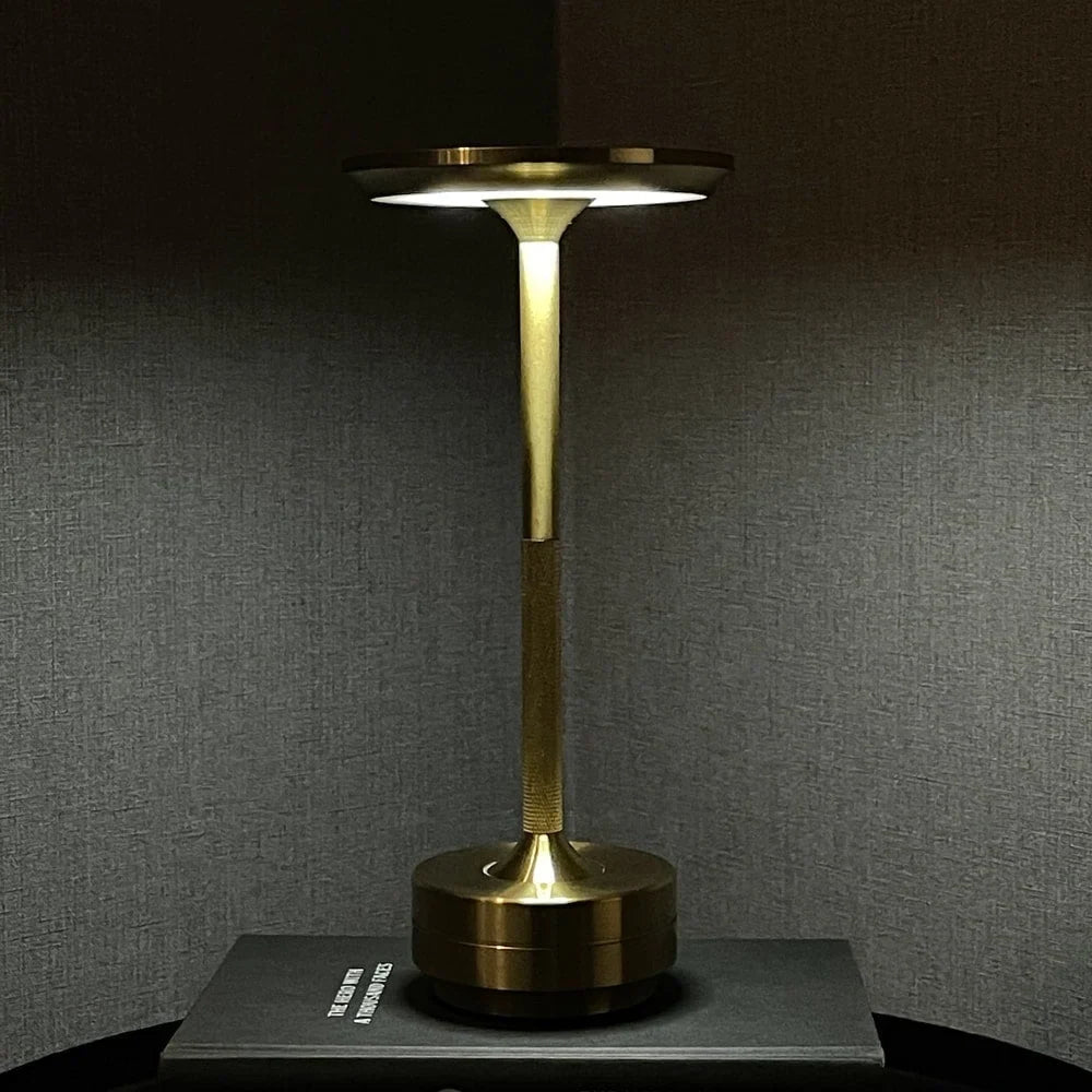 Aluminium cordless table lamp, lit in a room setting