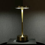 Aluminium cordless table lamp, lit in a room setting