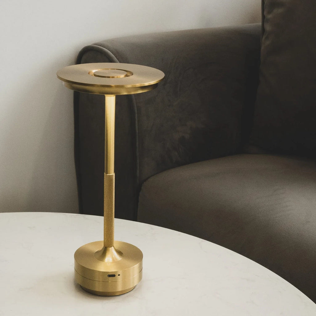 Aluminium cordless table lamp, lit in a room setting