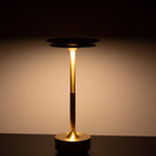 Aluminium cordless table lamp, lit in a room setting