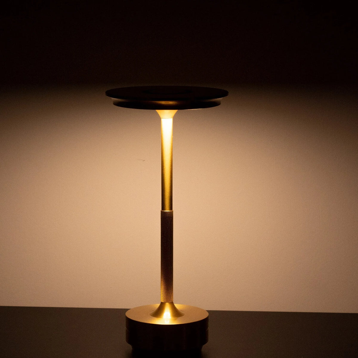 Aluminium cordless table lamp, lit in a room setting