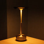 Aluminium cordless table lamp, lit in a room setting