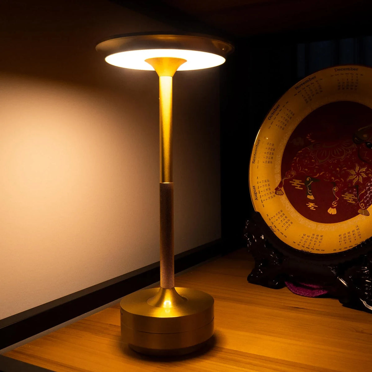 Aluminium cordless table lamp, lit in a room setting