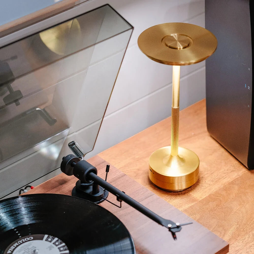 Aluminium cordless table lamp, beside a record player