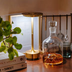 Aluminium cordless table lamp, lit in a room setting