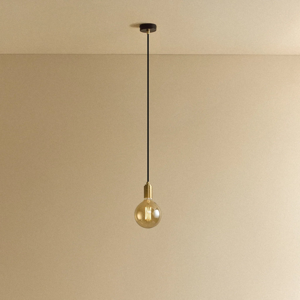 Amber filament globe bulb pendant, lit against a plain wall