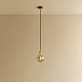 Amber filament globe bulb pendant, lit against a plain wall