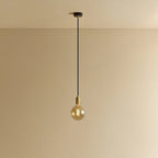Amber filament globe bulb pendant, lit against a plain wall