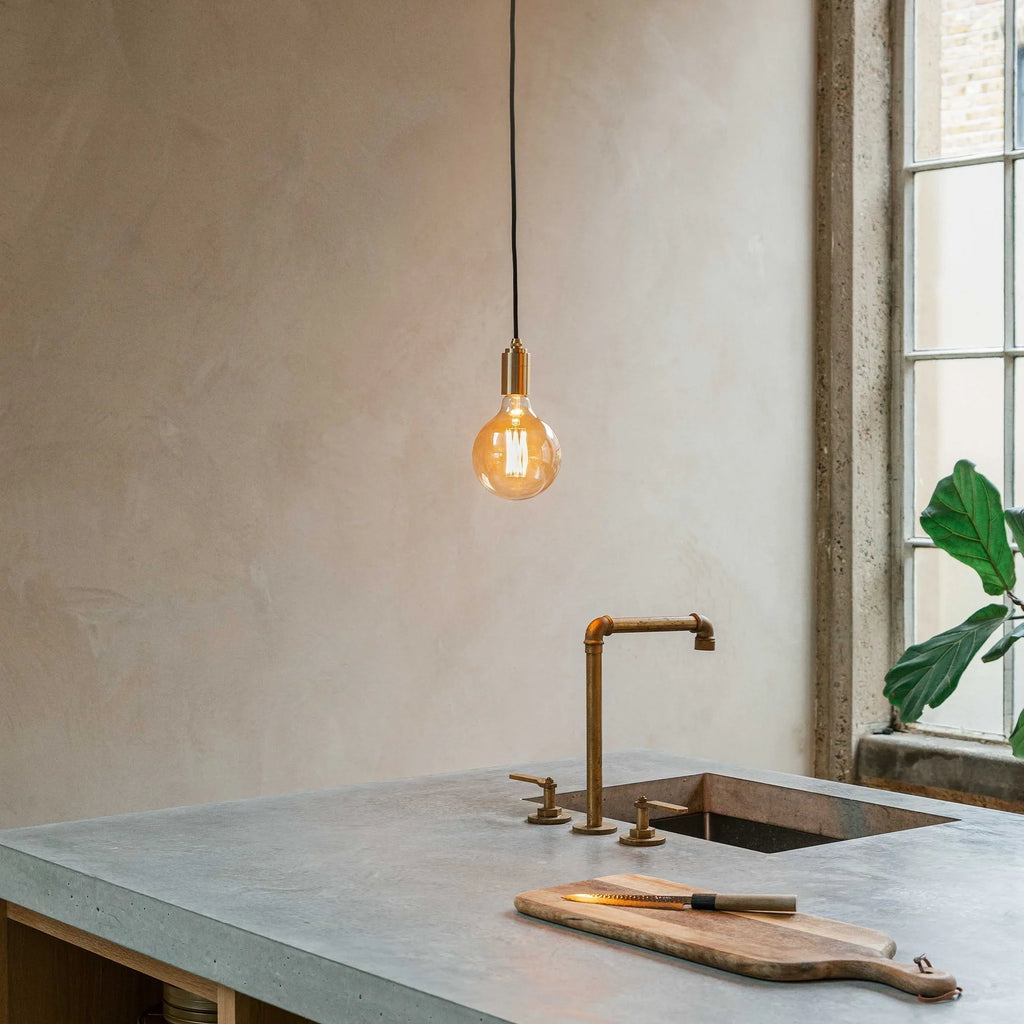 Amber filament globe bulb pendant, above a kitchen worktop