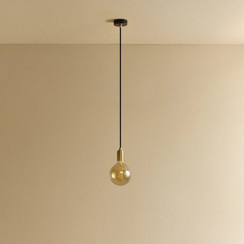 Amber filament globe bulb pendant, unlit against a plain wall
