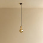 Amber tinted globe filament pendant, oak, lit, against a plain wall