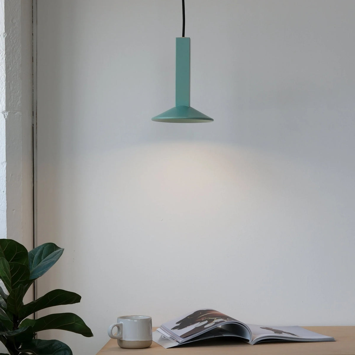 Angular stoneware spot pendant, in Bermuda green above a desk