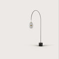 Arc floor lamp with a ribbed lantern shade and black marble foot, on a plain background