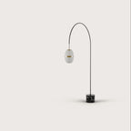 Arc floor lamp with a ribbed lantern shade and black marble foot, on a plain background