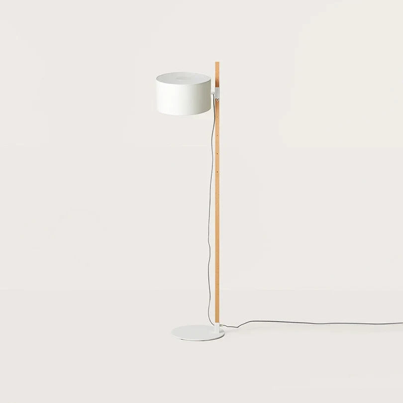 Beech upright floor lamp with an offset white drum shade, on a plain background