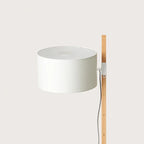 Beech upright floor lamp with an offset white drum shade, close-up of the drum shade and beech upright