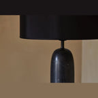 Marble pill-shaped table lamp, close-up of the black marble body