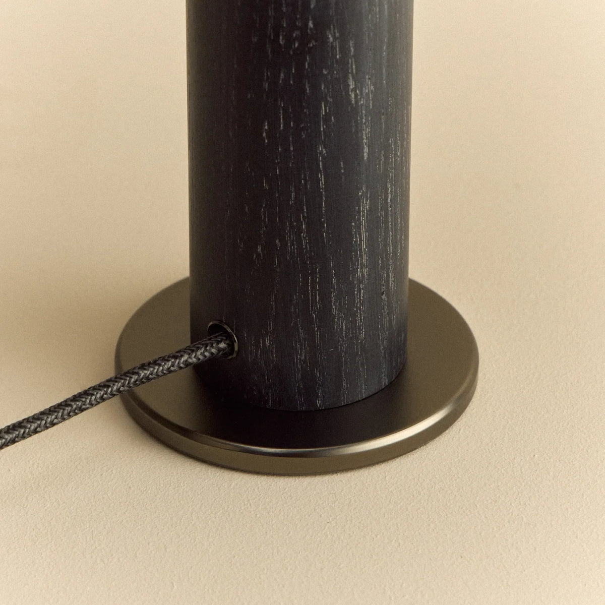 Blackened oak bulb holder table lamp, close-up of the gunmetal base and cable