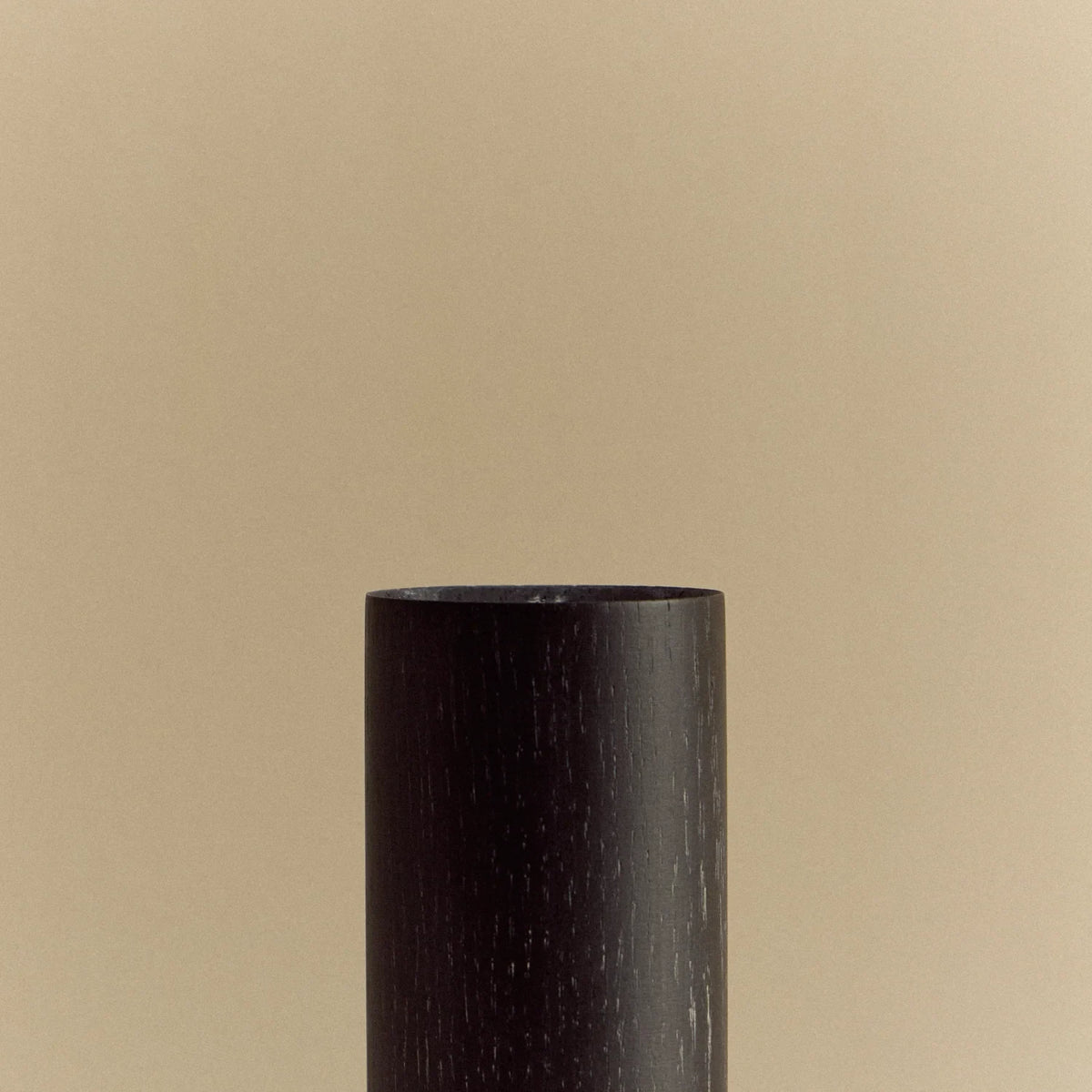 Blackened oak table lamp with a rounded square opal bulb, close-up of the wooden cylinder