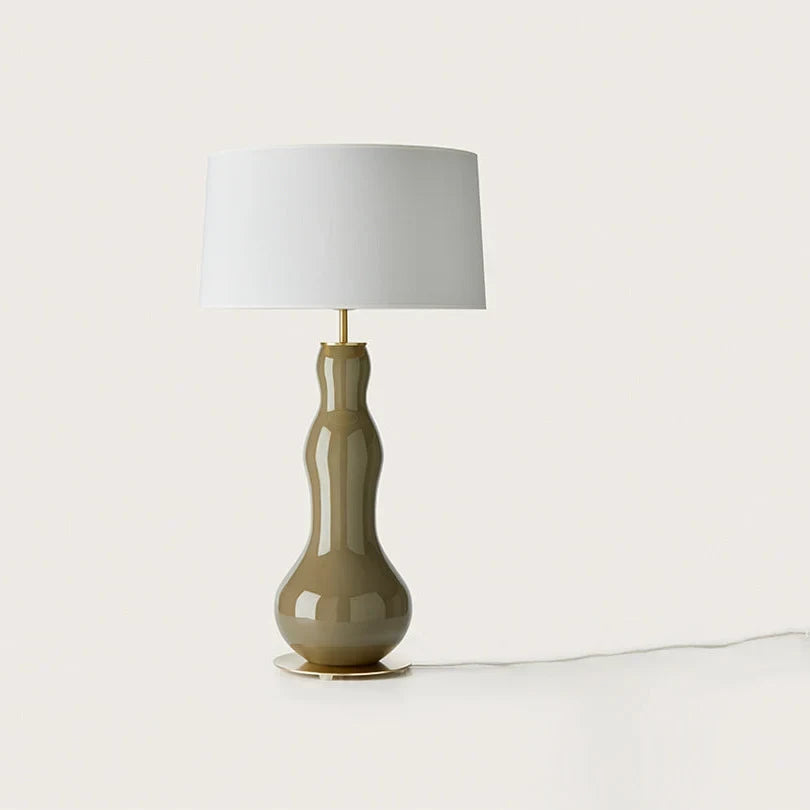 Bottle-shaped glass table lamp, in olive green, with a white shade (not included)