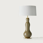 Bottle-shaped glass table lamp, in olive green, front view, with a shade (not included)