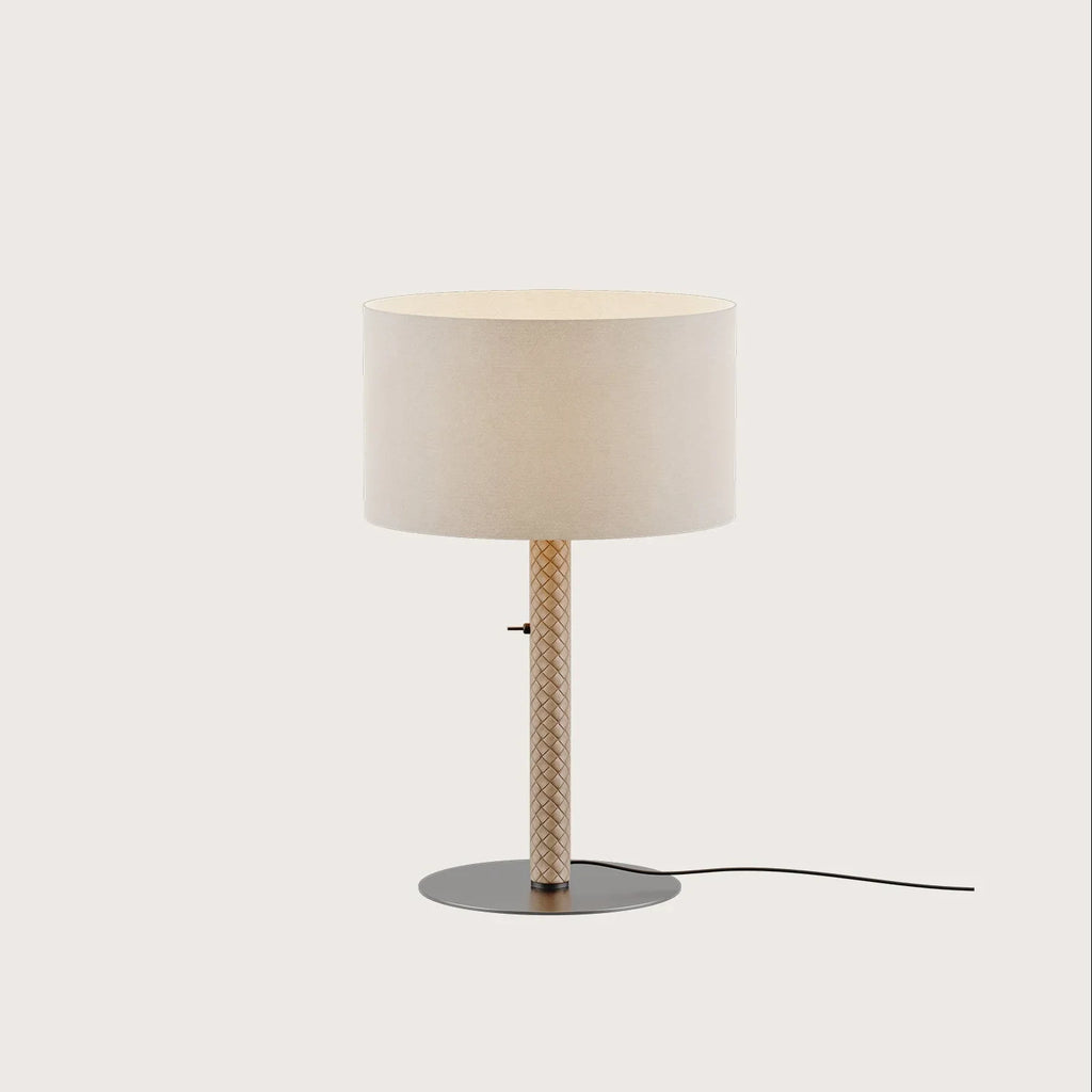 Braided leather column table lamp with drum shade, in taupe, on a plain background