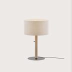 Braided leather column table lamp with drum shade, in taupe, on a plain background