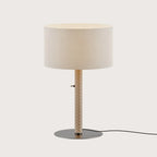 Braided leather column table lamp with drum shade, showing the metallic disc base