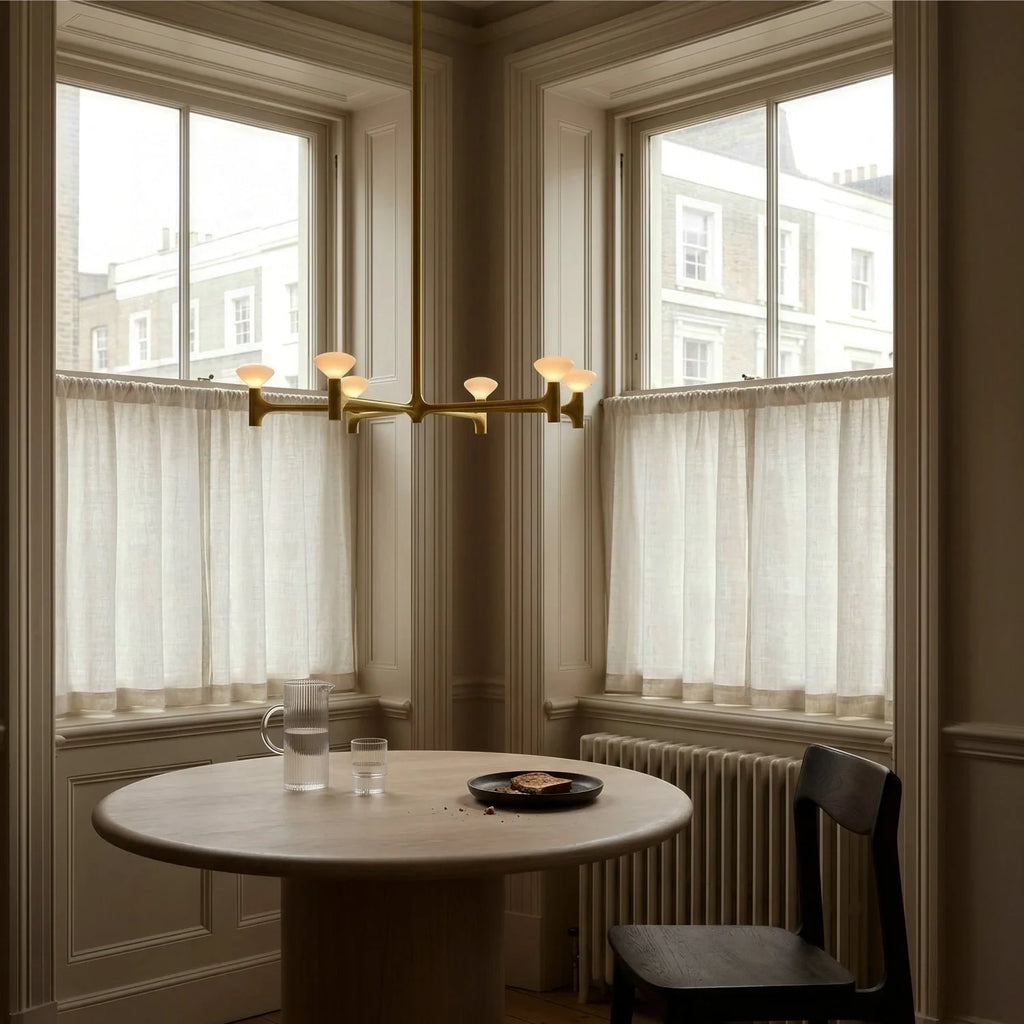 Branching brass chandelier, above a round table by a window