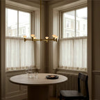 Branching brass chandelier, above a round table by a window